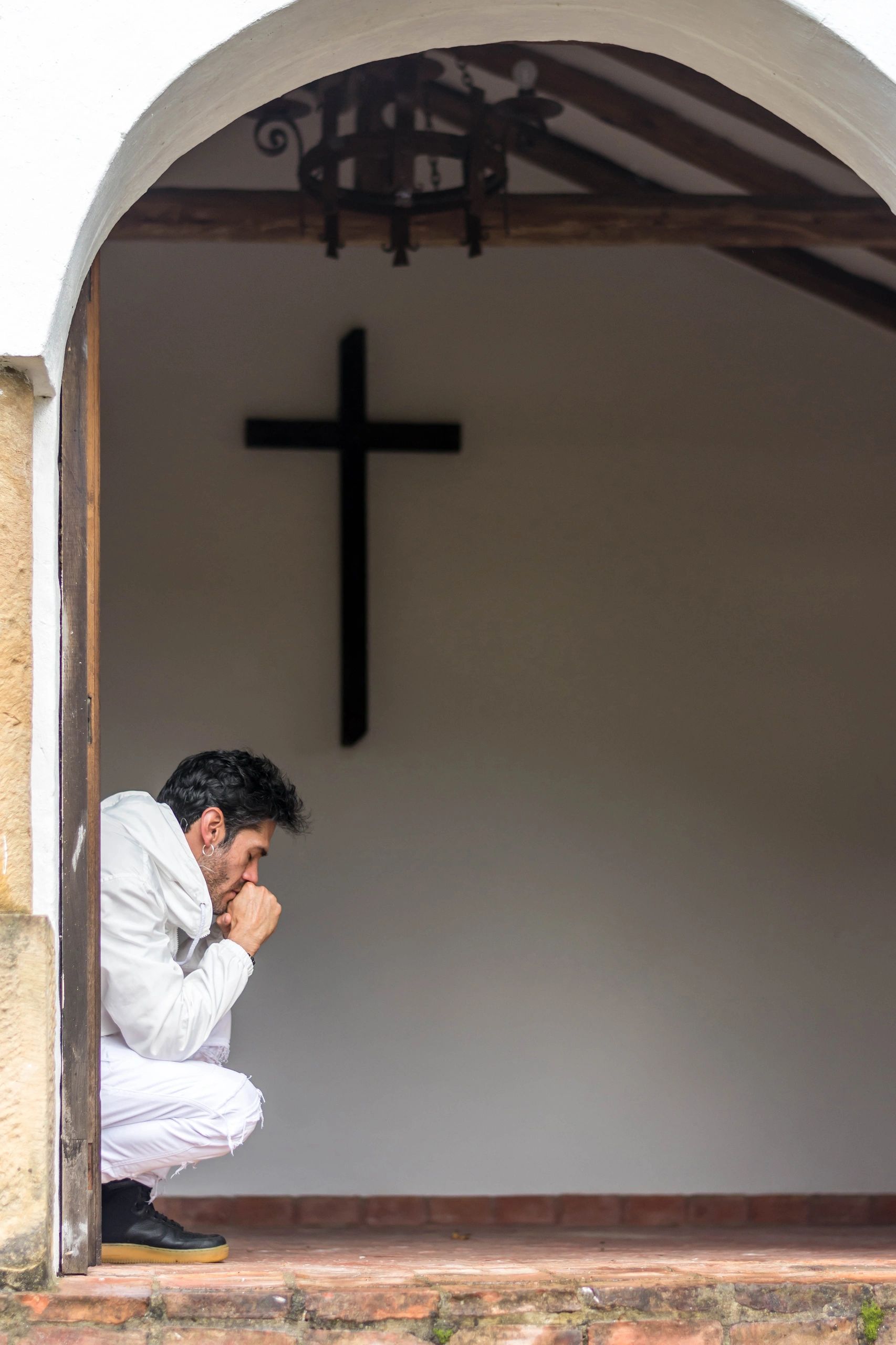 Young man praying at church entrance
